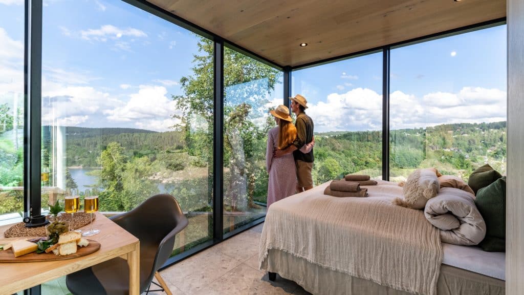 Et par som overnatter i en moderne hytte og som nyter utsikten