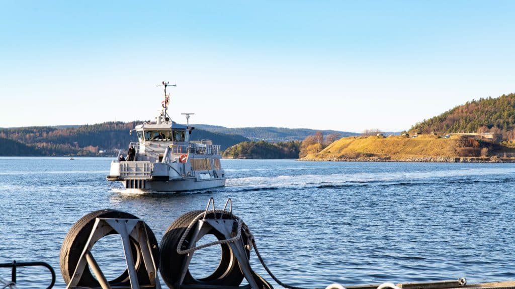 Oscarsborgfergen en sommerdag fra en brygge