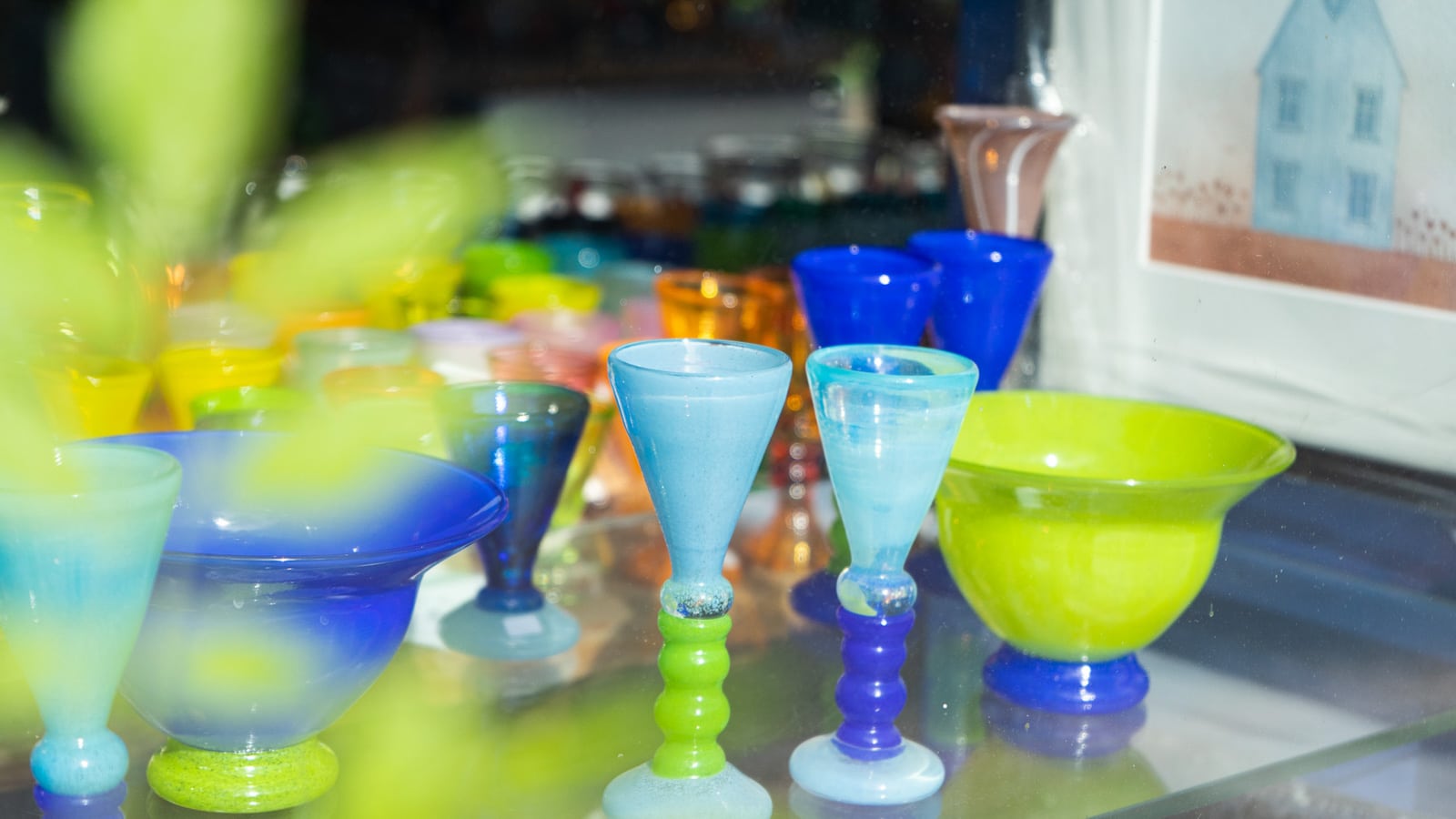Fargerike kunstglass i grønt og blått i vinduet til et galleri