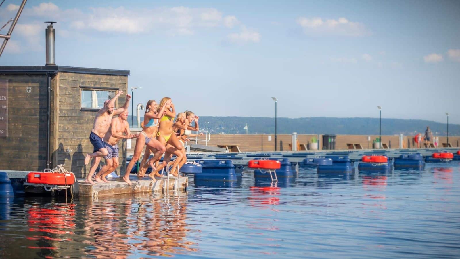 En gjeng hopper fra brygga ut i sjøen