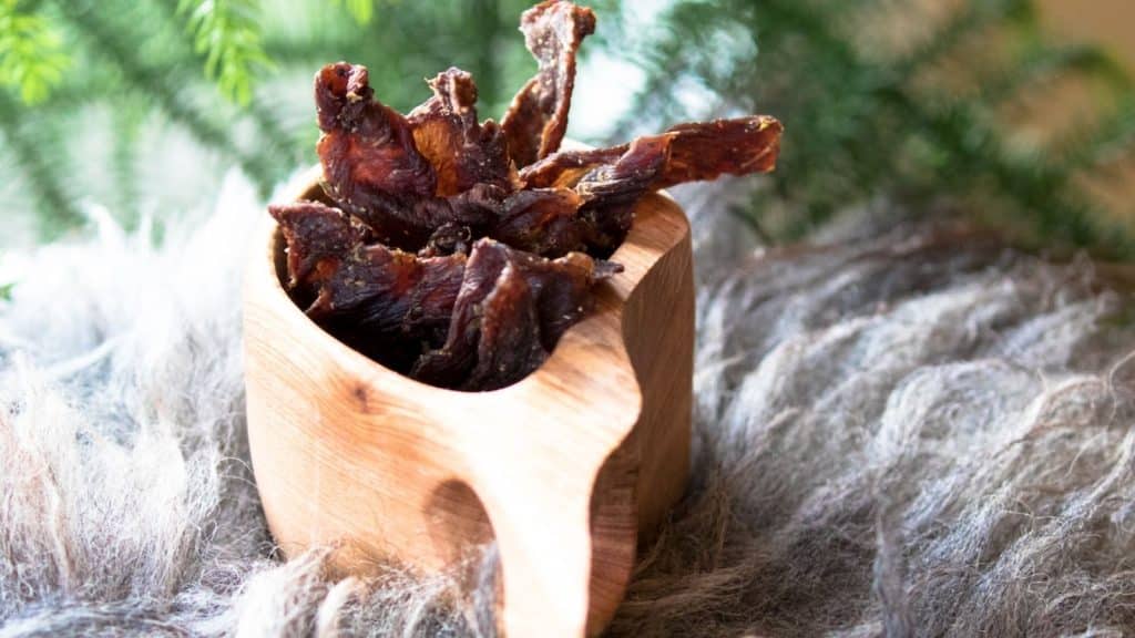 Spekemat i en kopp på et saueskinn