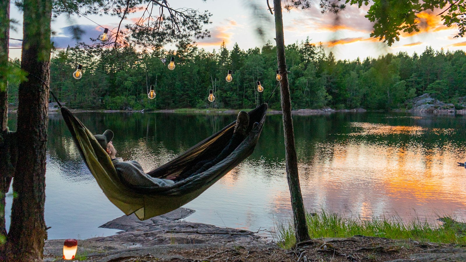 Mann i hengekøye ved innsjø