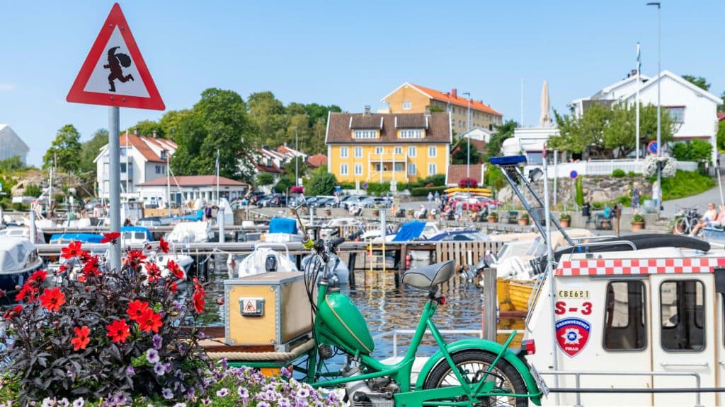 Nisseskilt fareskilt i en havn med blomster og en grønn sykkel