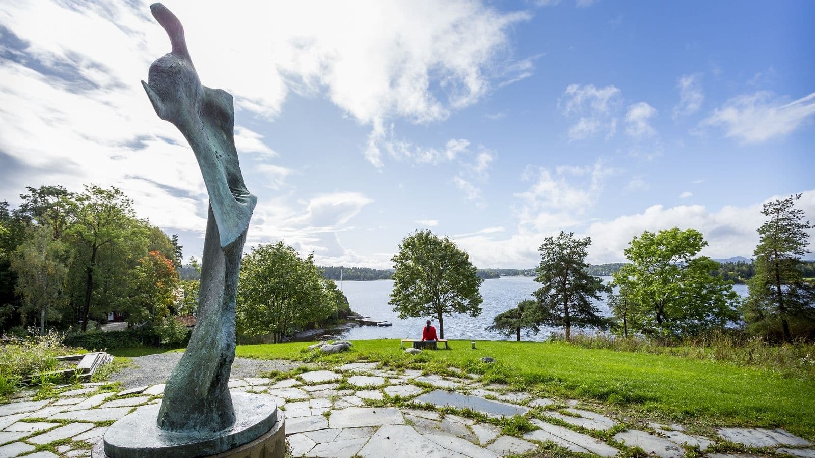 Henie Onstad Kunstsenter Utekunst dame sitter på en benk og ser utover Oslofjorden