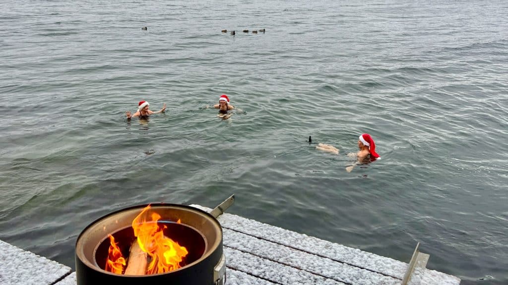 Tre personer som isbader i nisselue med bålpanne