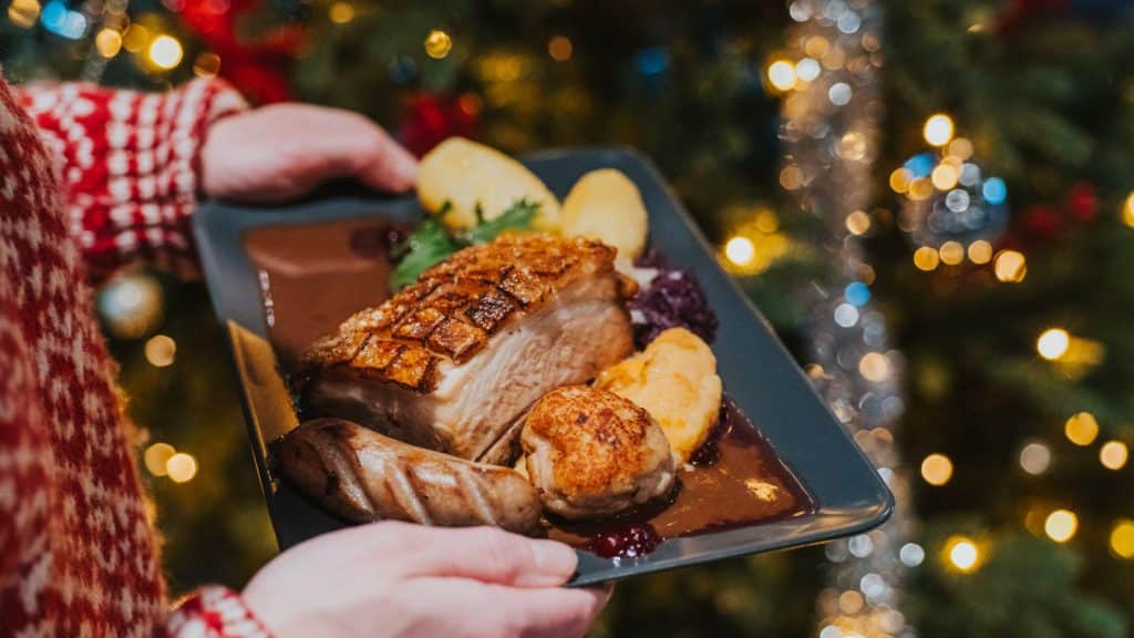 Christmas plate held in front of a Christmas tree