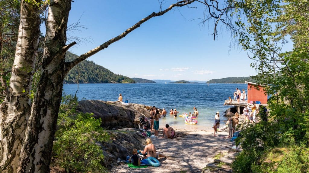 Badeplass med mennesker en sommerdag