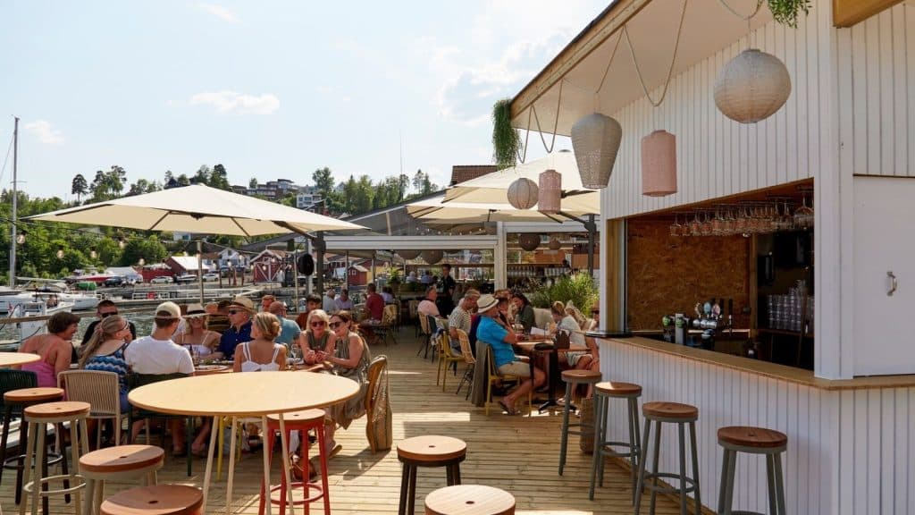Folk som koser seg på en bryggerestaurant i sola