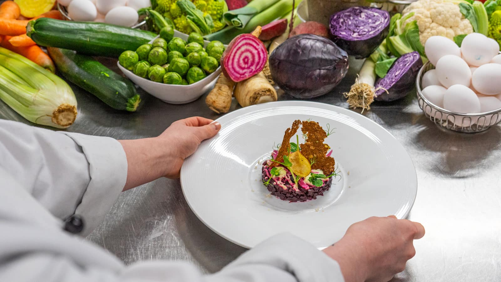 Rødbettartar med masse grønnsaker rundt på en tallerken