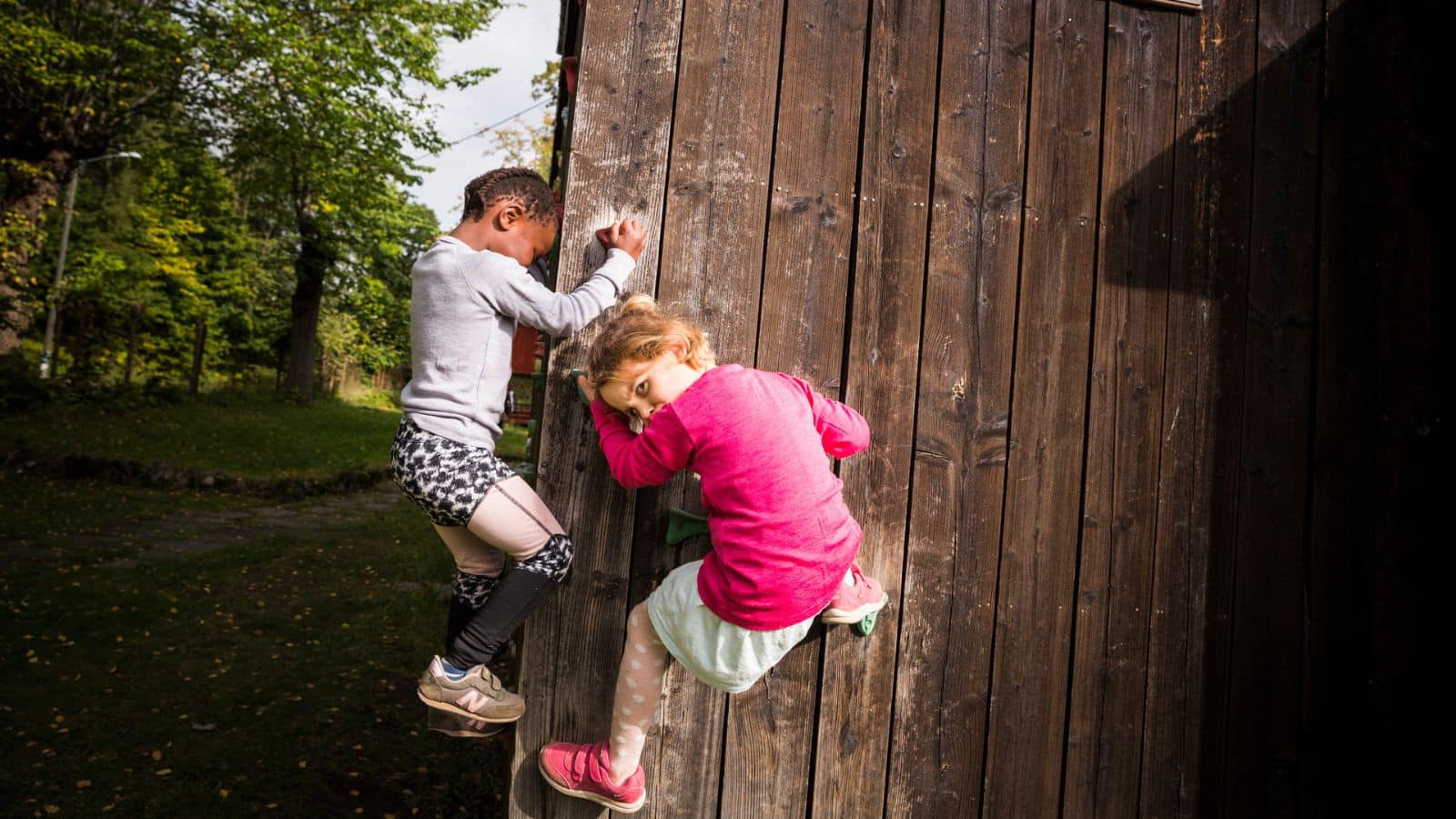 Barn leker klatrer på en vegg