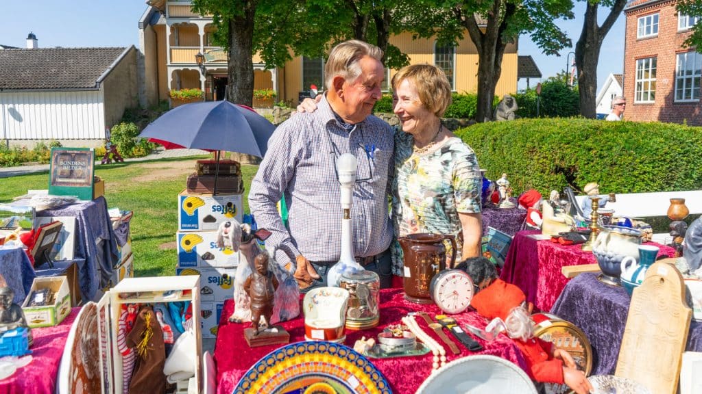 A couple who are market traders with a stall filled with antiques