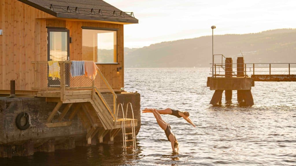 To damer hopper i vannet fra en badstue