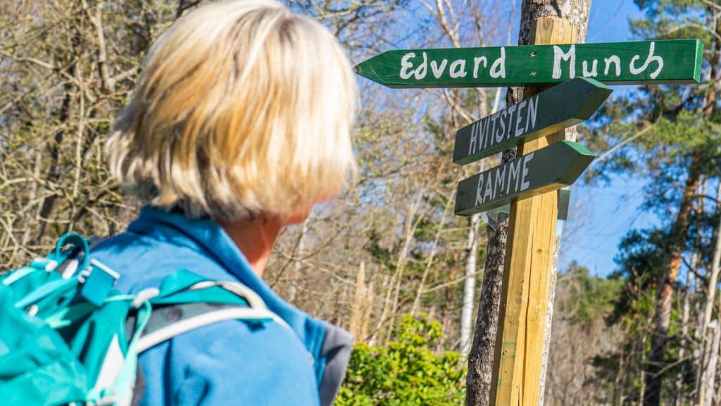 Dame som ser på et grønt skilt som det står Edvard Munch