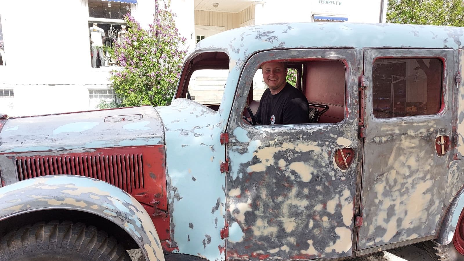 gammel bil med en mann sittende og kjører