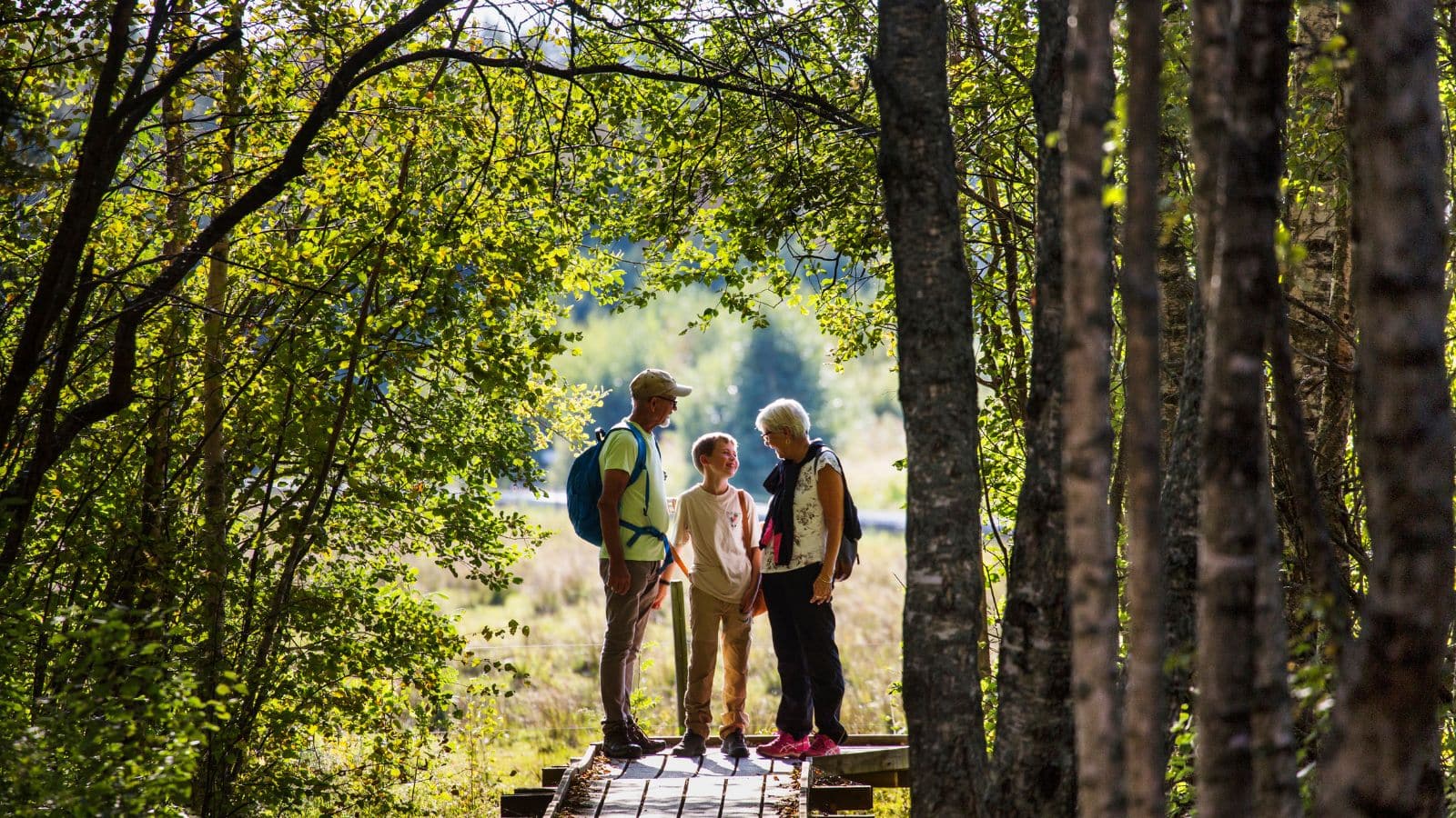 3 personer som står i en skog